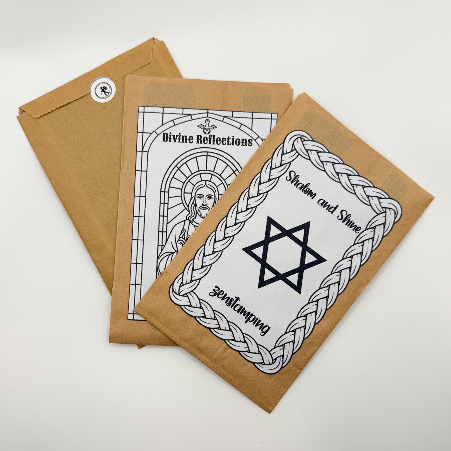 Three brown paper packages with black and white religious designs on a white background