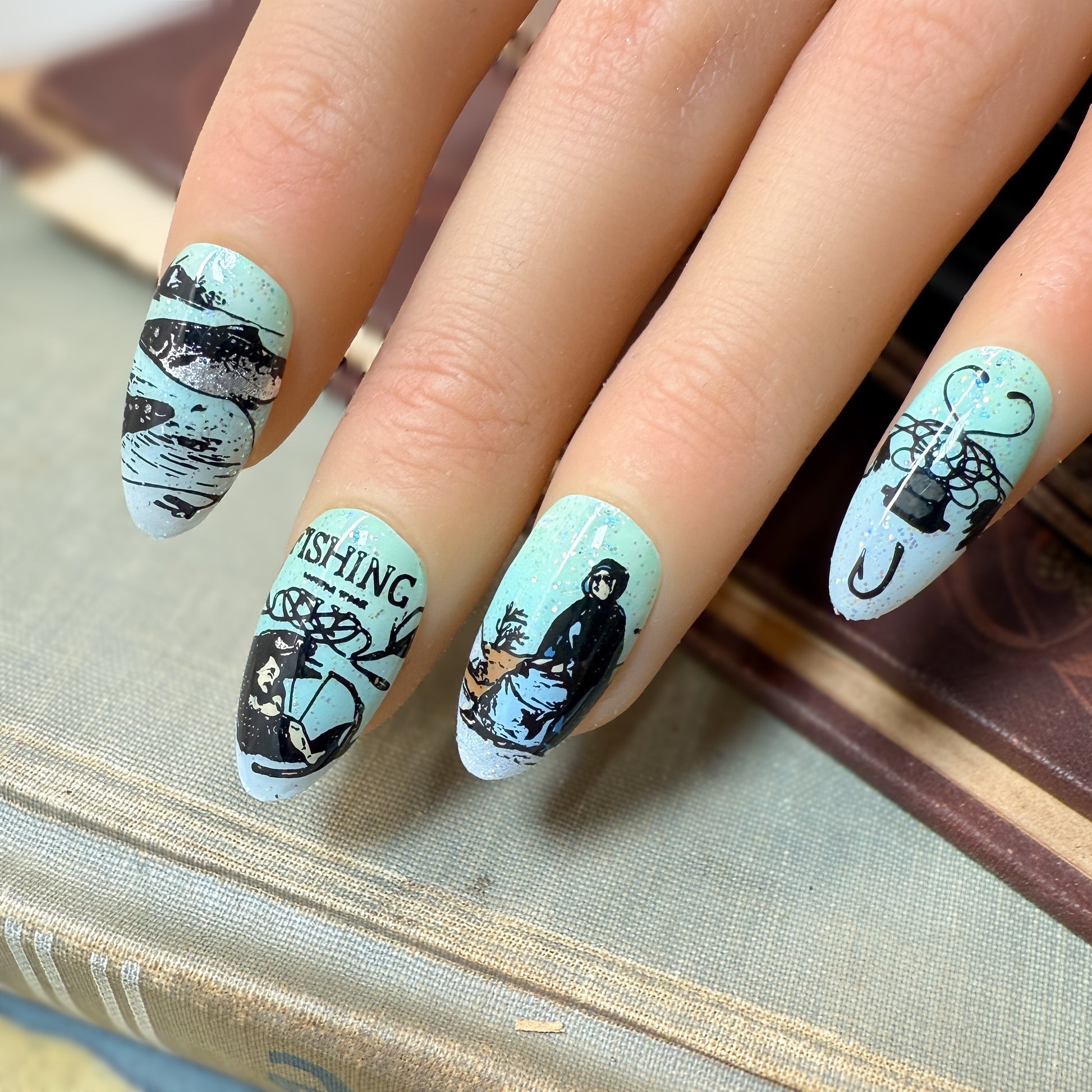Nails with fishing-themed design on a book background