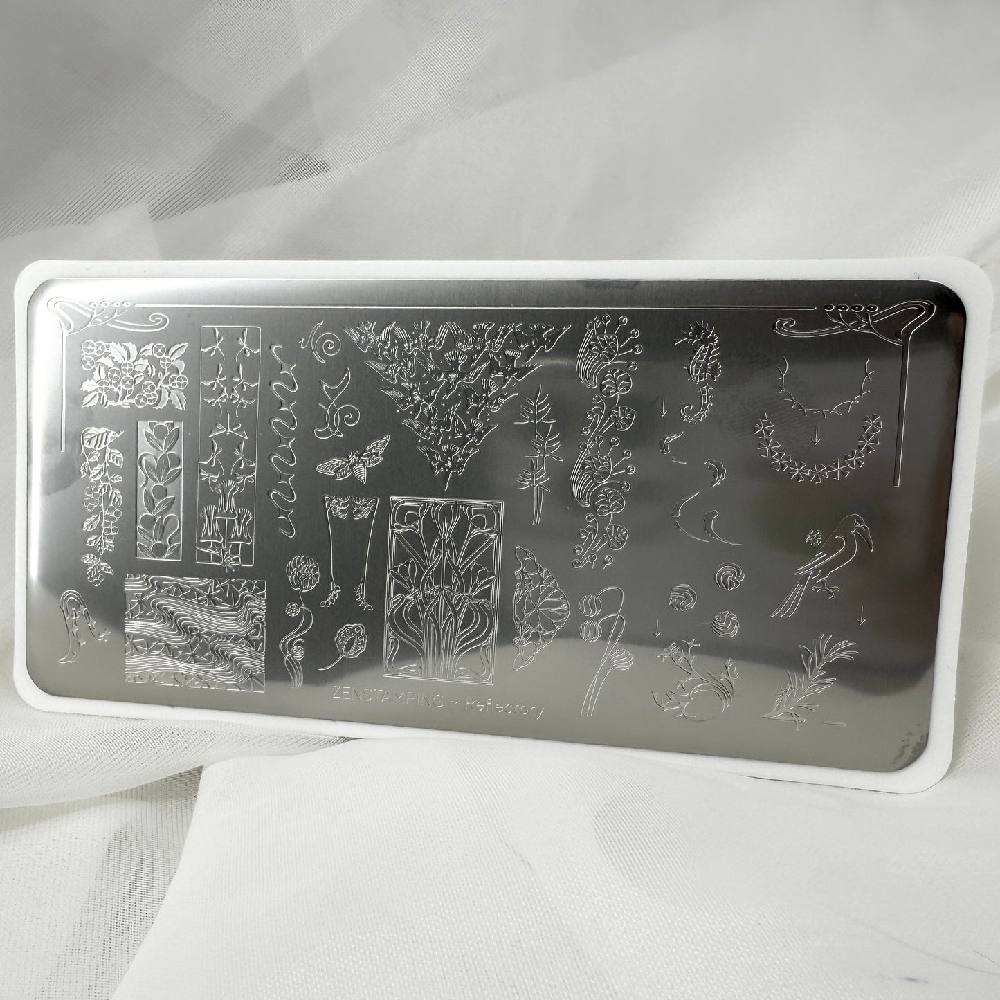 Nail art stamping plate with various designs on a white background