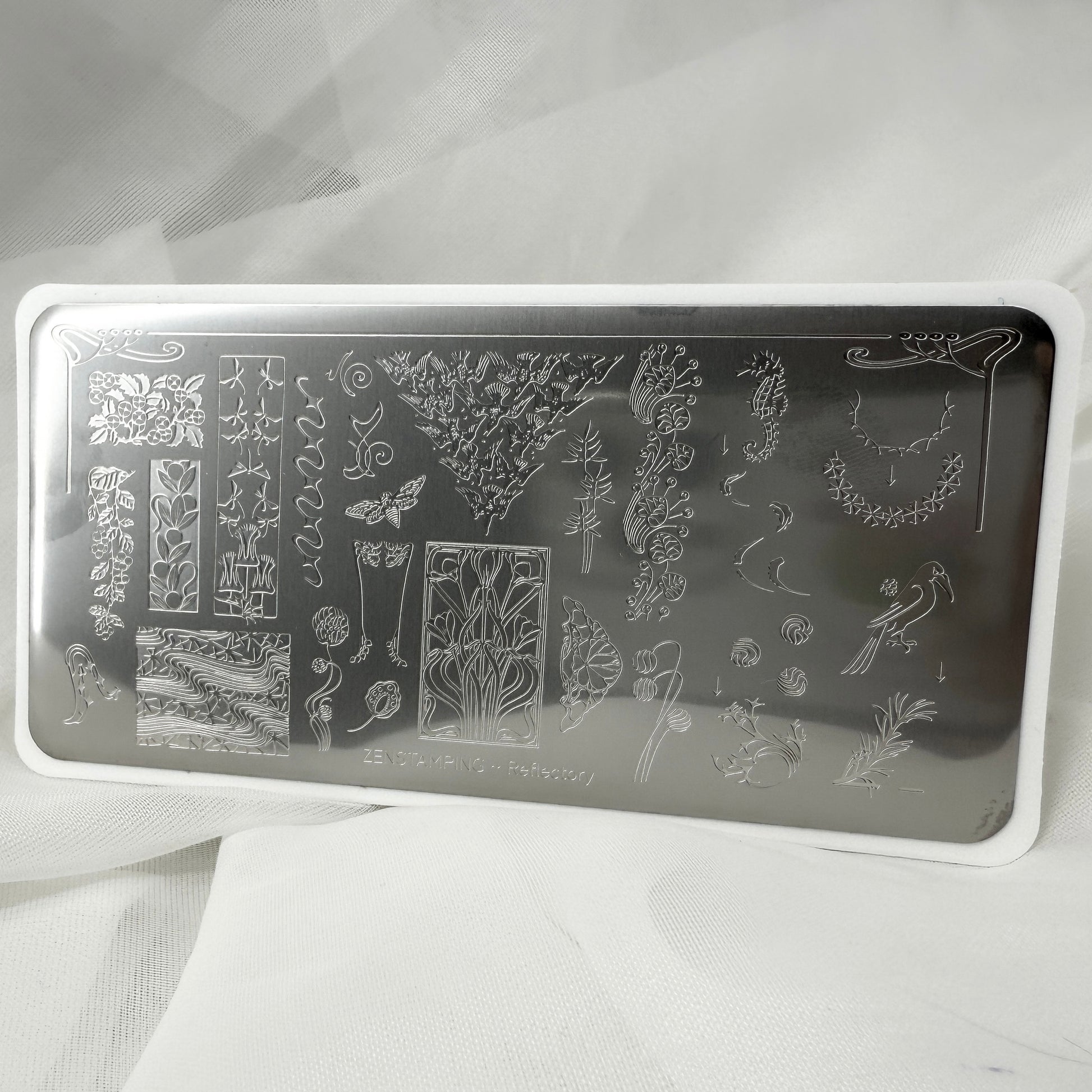 Nail art stamping plate with various designs on a white background