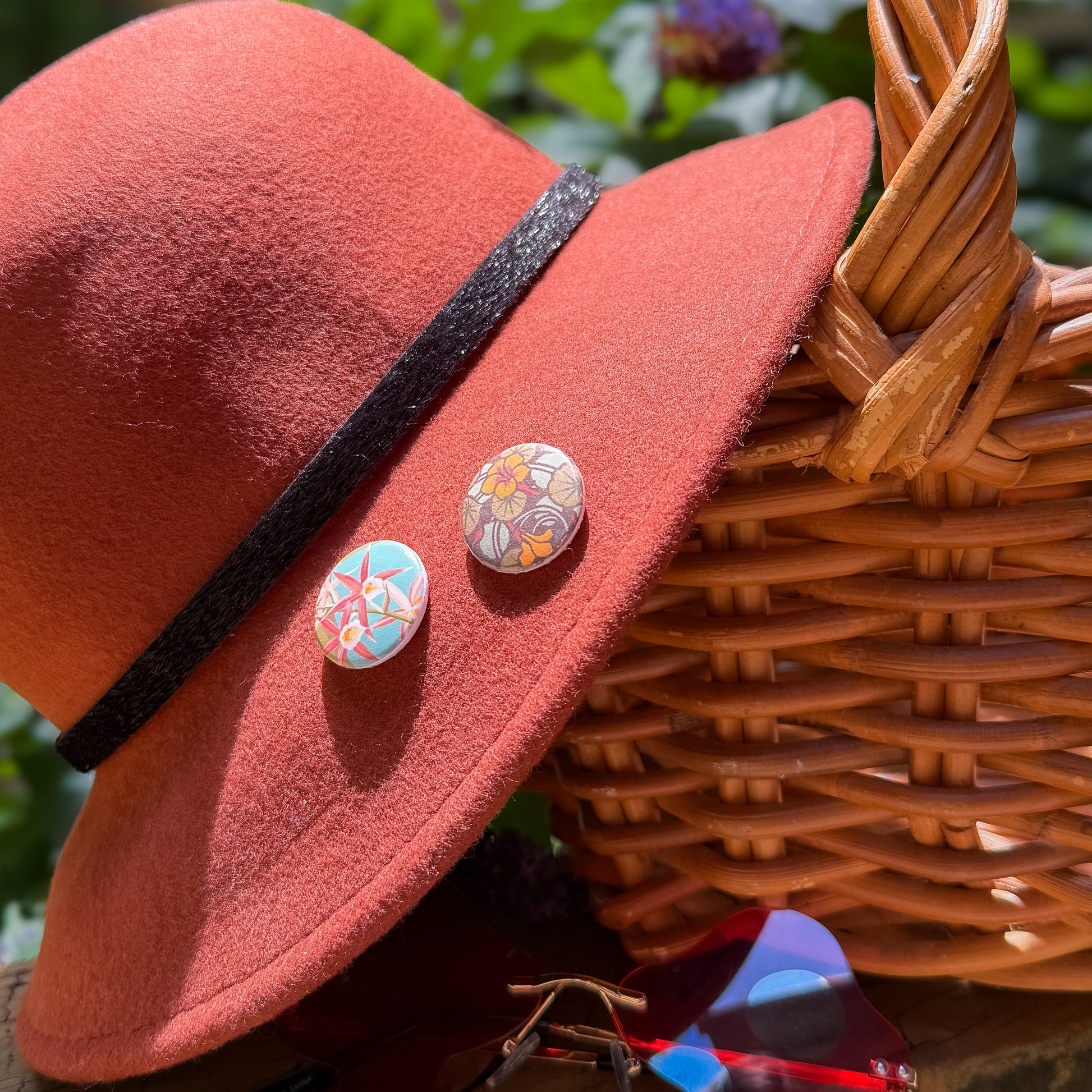Red hat with decorative buttons on a wicker basket against a natural background
